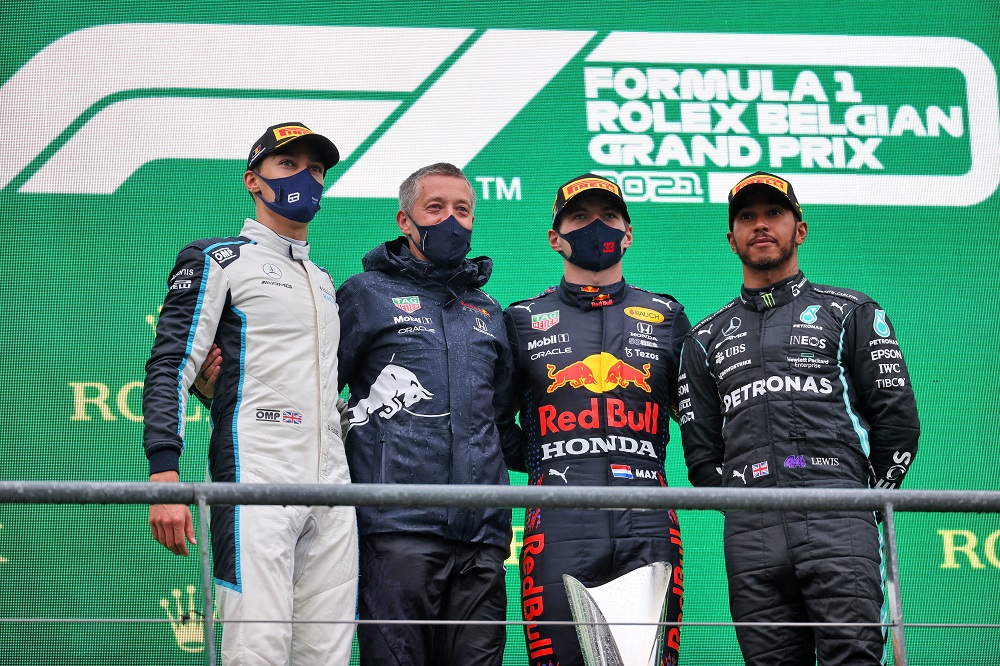 Podio del GP de Bélgica 2021 en Spa-Francorchamps con George Russell, un miembro del equipo Red Bull, Max Verstappen y Lewis Hamilton, con mascarillas, celebrando en una ceremonia breve