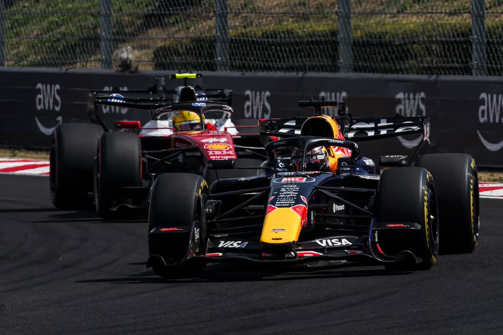 Max Verstappen liderando a Lewis Hamilton en pista durante el GP de Hungría 2026, vista desde atrás en una curva del Hungaroring