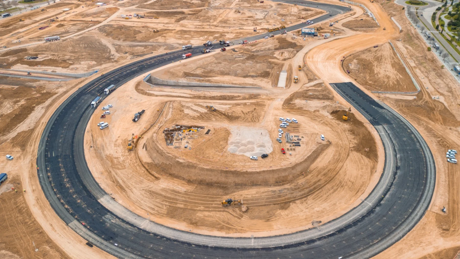 Vista aérea de las obras de construcción del Madring, con el asfalto de las curvas ya terminado mientras continúan los trabajos en gradas y zonas de aficionados