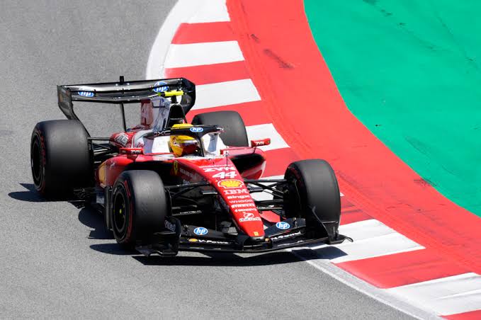 Ferrari de Lewis Hamilton en solitario tomando una curva del Hungaroring con pianos rojo, blanco y verde durante el GP de Hungría 2026